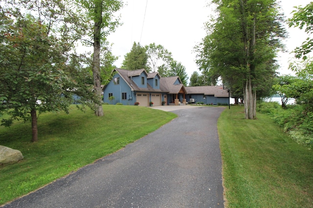 2150 Danish Landing Rd, Grayling, MI 49738 - cape cod-style house featuring an attached garage, driveway, and a front lawn