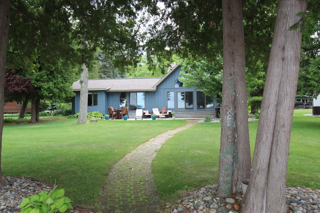 2150 Danish Landing Rd, Grayling, MI 49738 - back of house featuring a lawn, a patio, board and batten siding, and a shingled roof