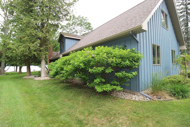2150 Danish Landing Rd, Grayling, MI 49738 - view of side of property with a shingled roof, a yard, and board and batten siding