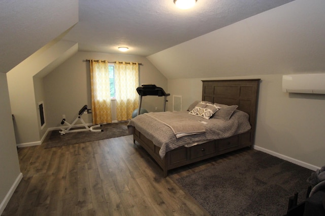 2150 Danish Landing Rd, Grayling, MI 49738 - bedroom featuring a wall mounted AC, dark wood-style floors, and vaulted ceiling