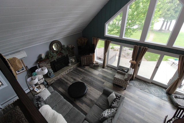 2150 Danish Landing Rd, Grayling, MI 49738 - living room featuring vaulted ceiling, an AC wall unit, wood finished floors, and a stone fireplace