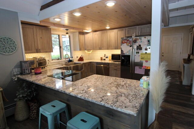 2150 Danish Landing Rd, Grayling, MI 49738 - kitchen featuring stainless steel appliances, a peninsula, light stone counters, dark wood-style flooring, and decorative backsplash