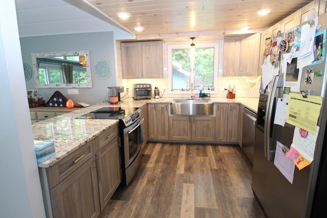 2150 Danish Landing Rd, Grayling, MI 49738 - kitchen featuring appliances with stainless steel finishes, a peninsula, dark wood-style flooring, light stone counters, and backsplash