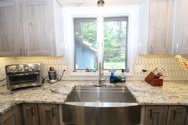 2150 Danish Landing Rd, Grayling, MI 49738 - kitchen with tasteful backsplash and light stone counters