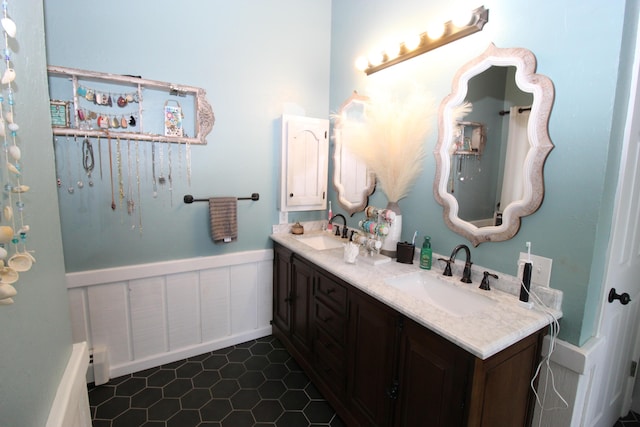 2150 Danish Landing Rd, Grayling, MI 49738 - full bath featuring double vanity, a wainscoted wall, and tile patterned flooring