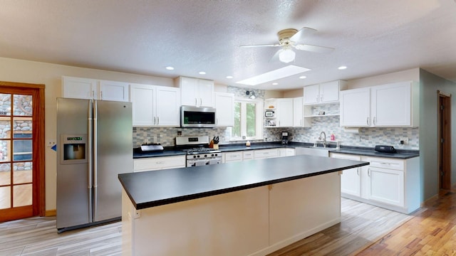 7090 Nancy K Dr, Hale, MI 48739 - kitchen featuring appliances with stainless steel finishes, open shelves, a ceiling fan, light wood-style floors, and a textured ceiling