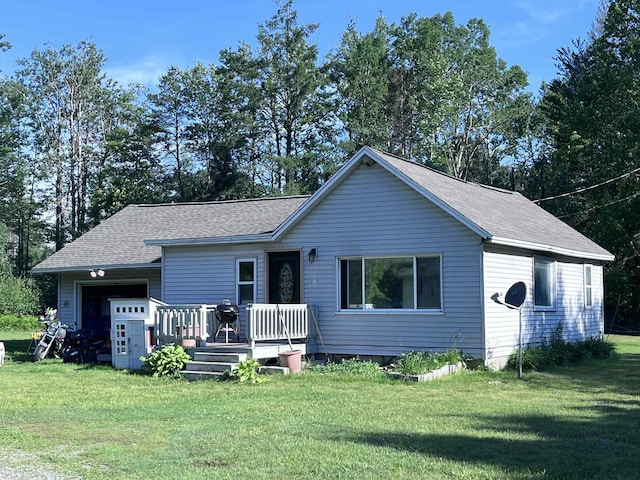 4130 Werth Rd, Alpena, MI 49707 - ranch-style home with a front lawn, an attached garage, a shingled roof, and a deck