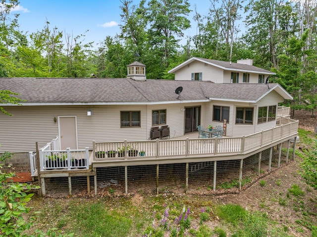 982 Shaggy Bark Ct, Gaylord, MI 49735 - rear view of house featuring a wooden deck, a shingled roof, and view of wooded area
