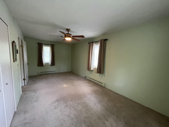 982 Shaggy Bark Ct, Gaylord, MI 49735 - spare room featuring a baseboard radiator, baseboard heating, light colored carpet, and plenty of natural light
