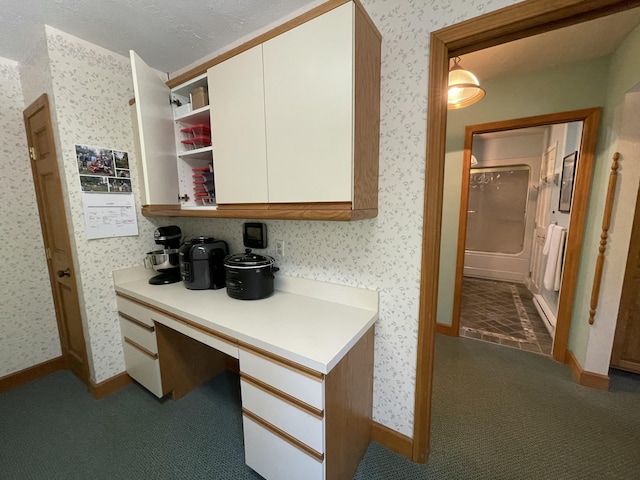 982 Shaggy Bark Ct, Gaylord, MI 49735 - kitchen featuring built in study area, light countertops, carpet flooring, open shelves, and white cabinetry