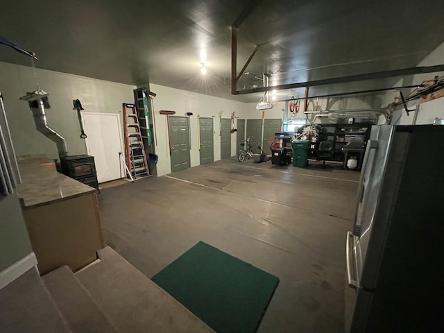 982 Shaggy Bark Ct, Gaylord, MI 49735 - garage featuring freestanding refrigerator and a wood stove