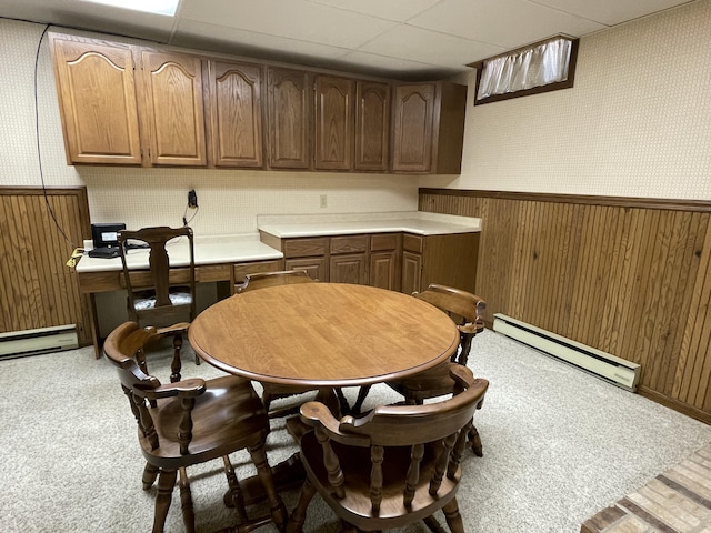 982 Shaggy Bark Ct, Gaylord, MI 49735 - dining area featuring a baseboard heating unit, wallpapered walls, wainscoting, carpet, and wood walls