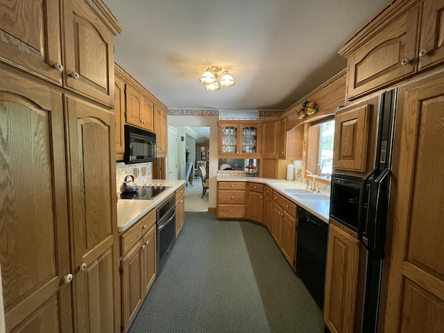 982 Shaggy Bark Ct, Gaylord, MI 49735 - kitchen with black appliances, light countertops, dark colored carpet, glass insert cabinets, and brown cabinets