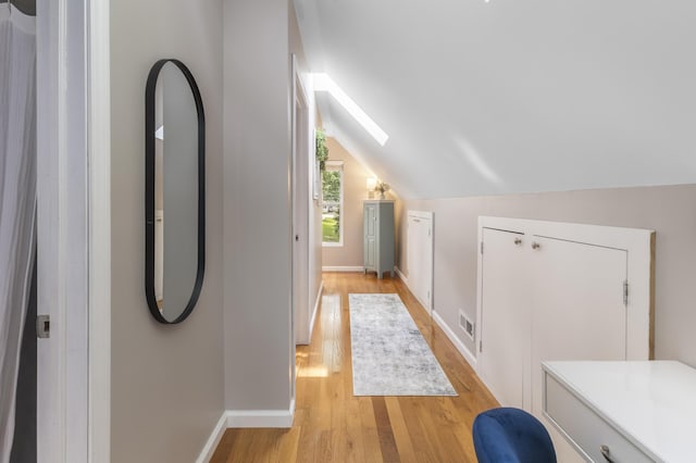 3974 W Houghton Lake Dr, Houghton Lake, MI 48629 - corridor with light wood-type flooring, a skylight, and vaulted ceiling