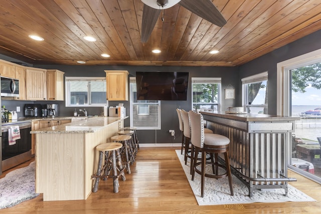 3974 W Houghton Lake Dr, Houghton Lake, MI 48629 - kitchen featuring appliances with stainless steel finishes, light brown cabinetry, wood ceiling, recessed lighting, and light wood-style floors