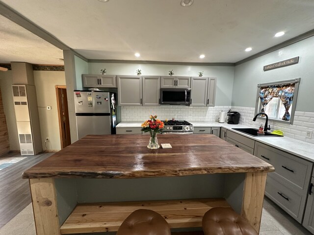 5127 Crestwood Rd, Lewiston, MI 49756 - kitchen featuring stainless steel appliances, gray cabinets, a heating unit, a center island, and ornamental molding
