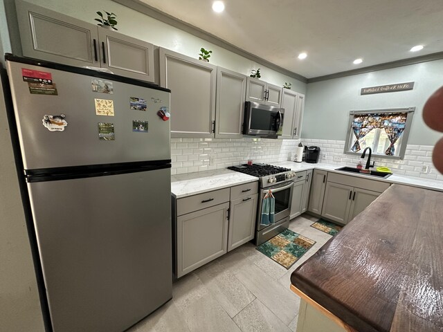 5127 Crestwood Rd, Lewiston, MI 49756 - kitchen with appliances with stainless steel finishes, gray cabinets, decorative backsplash, ornamental molding, and recessed lighting