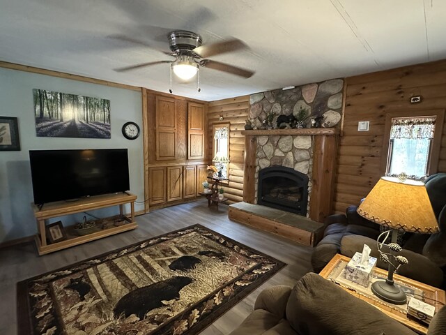 5127 Crestwood Rd, Lewiston, MI 49756 - living area featuring log walls, a fireplace, a ceiling fan, and wood finished floors