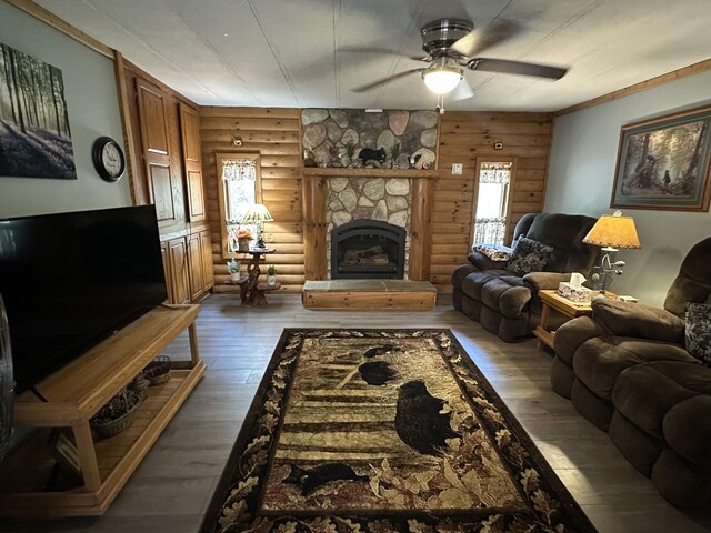 5127 Crestwood Rd, Lewiston, MI 49756 - living room with log walls, ceiling fan, a fireplace, and hardwood / wood-style flooring