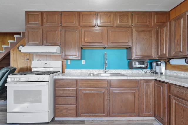 12328 W Shore Dr, Houghton Lake, MI 48629 - kitchen with white range with gas stovetop, extractor fan, and brown cabinetry