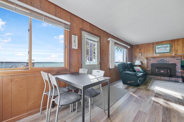 12328 W Shore Dr, Houghton Lake, MI 48629 - dining area featuring wooden walls, light wood-style flooring, and a water view