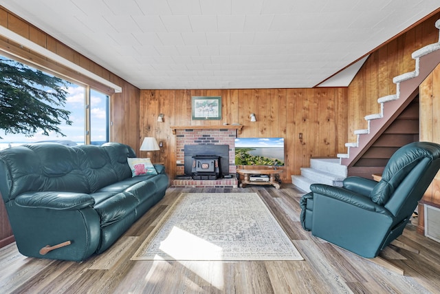 12328 W Shore Dr, Houghton Lake, MI 48629 - living room featuring stairs, wood finished floors, a wood stove, and wooden walls