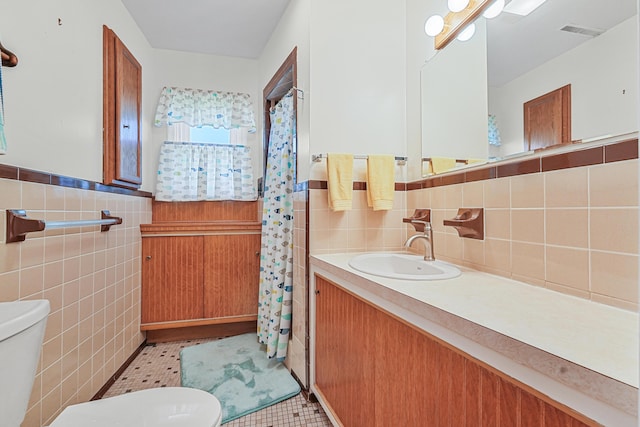 12328 W Shore Dr, Houghton Lake, MI 48629 - bathroom with tile walls, vanity, wainscoting, tile patterned floors, and a shower with curtain