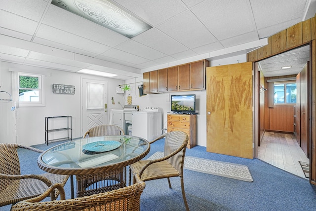 12328 W Shore Dr, Houghton Lake, MI 48629 - dining room featuring washer and clothes dryer, light carpet, healthy amount of natural light, a paneled ceiling, and wooden walls