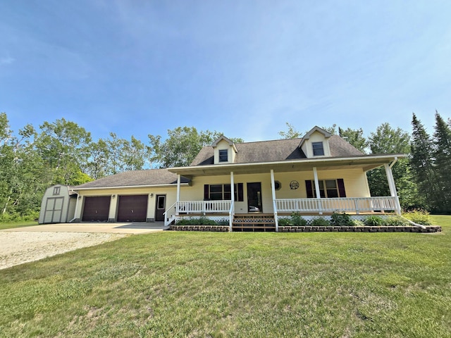 N705 Woods Rd, Saint Ignace, MI 49781 - view of front facade with a porch, a storage shed, concrete driveway, an attached garage, and a front yard