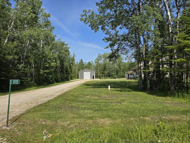 N705 Woods Rd, Saint Ignace, MI 49781 - view of green lawn featuring driveway, a garage, and an outbuilding