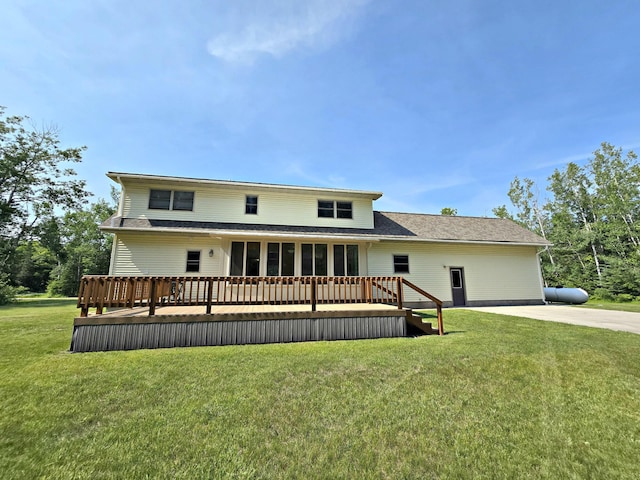 N705 Woods Rd, Saint Ignace, MI 49781 - back of property featuring a lawn, a wooden deck, roof with shingles, and a sunroom