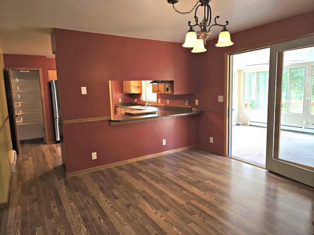 N705 Woods Rd, Saint Ignace, MI 49781 - kitchen featuring dark wood finished floors, a chandelier, a peninsula, freestanding refrigerator, and hanging light fixtures