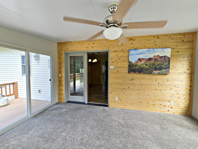 N705 Woods Rd, Saint Ignace, MI 49781 - empty room featuring carpet, wood walls, and ceiling fan