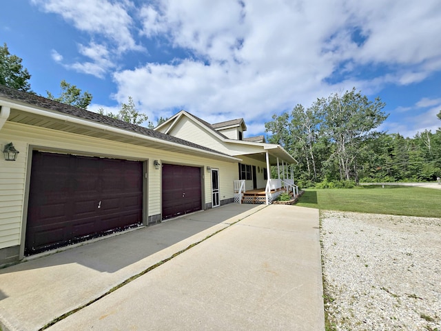 N705 Woods Rd, Saint Ignace, MI 49781 - view of side of property featuring a yard, an attached garage, a porch, and driveway