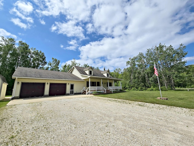 N705 Woods Rd, Saint Ignace, MI 49781 - view of front facade with a porch, dirt driveway, a garage, and a front yard