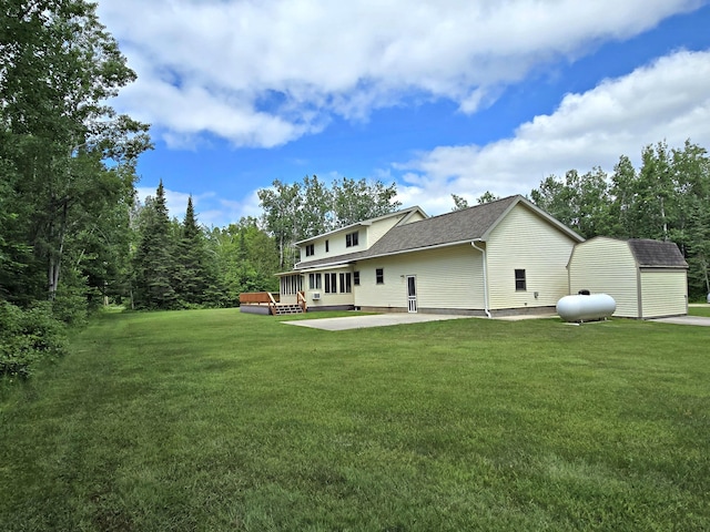 N705 Woods Rd, Saint Ignace, MI 49781 - back of property featuring a yard, a patio area, a shingled roof, and a wooden deck