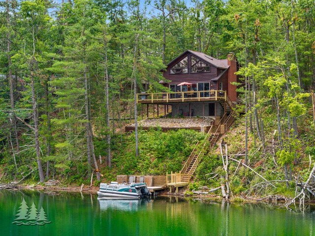 6609 Honey Ln, Johannesburg, MI 49751 - rear view of property featuring stairway, a chimney, a wooded view, and a deck with water view