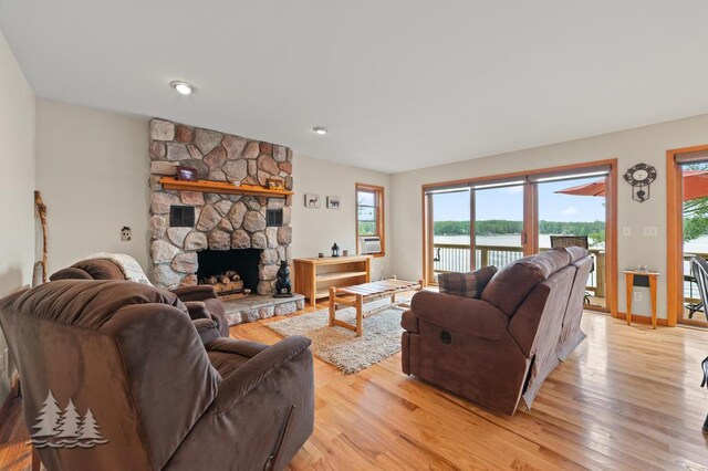 6609 Honey Ln, Johannesburg, MI 49751 - living room with light wood finished floors, a fireplace, and a water view