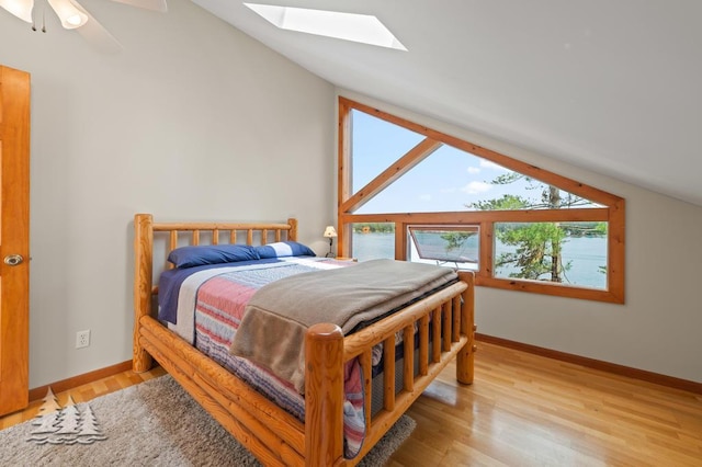 6609 Honey Ln, Johannesburg, MI 49751 - bedroom featuring vaulted ceiling, a skylight, light wood-style flooring, and a ceiling fan