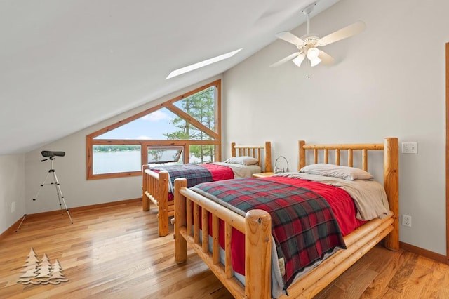 6609 Honey Ln, Johannesburg, MI 49751 - bedroom featuring lofted ceiling, a skylight, light wood-style flooring, and a ceiling fan