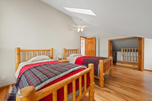 6609 Honey Ln, Johannesburg, MI 49751 - bedroom featuring vaulted ceiling, a skylight, light wood-type flooring, and a ceiling fan