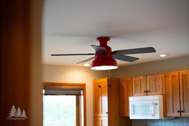 6609 Honey Ln, Johannesburg, MI 49751 - detailed view of white microwave, ceiling fan, and brown cabinetry