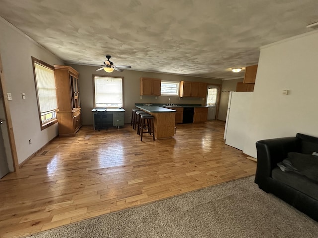 4974 Meridian Line Rd, Johannesburg, MI 49751 - kitchen with freestanding refrigerator, black dishwasher, ornamental molding, a kitchen breakfast bar, and dark countertops