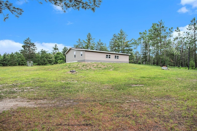 6691 Boone Ln, Vanderbilt, MI 49795 - view of green lawn featuring a storage unit