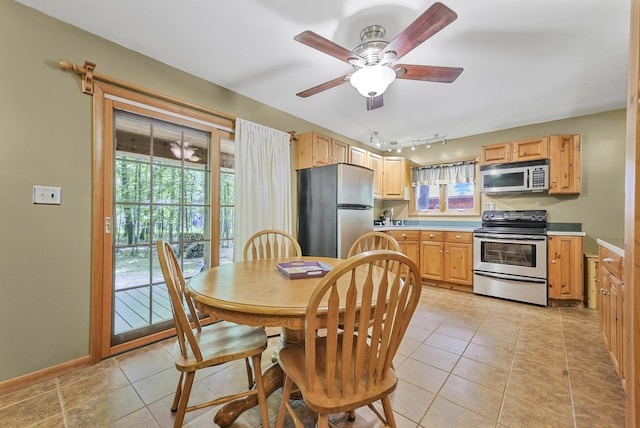 120 Clyde St, Roscommon, MI 48653 - kitchen featuring appliances with stainless steel finishes, light countertops, light tile patterned flooring, and track lighting