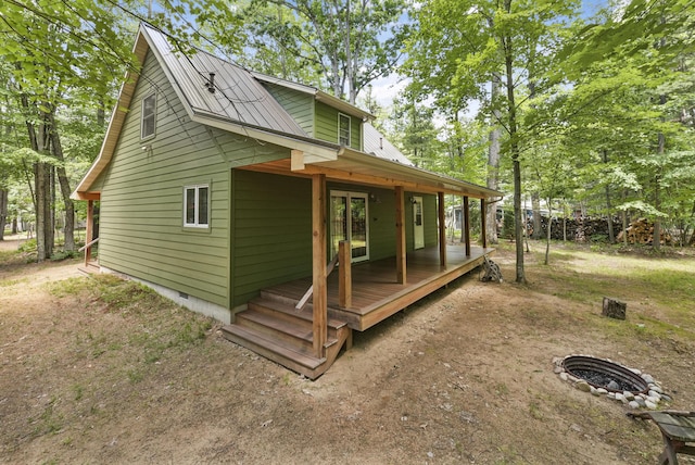 120 Clyde St, Roscommon, MI 48653 - view of property exterior with a fire pit, a metal roof, crawl space, and a deck