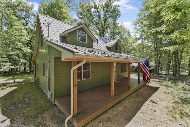 120 Clyde St, Roscommon, MI 48653 - view of side of home featuring a metal roof, a deck, and a standing seam roof