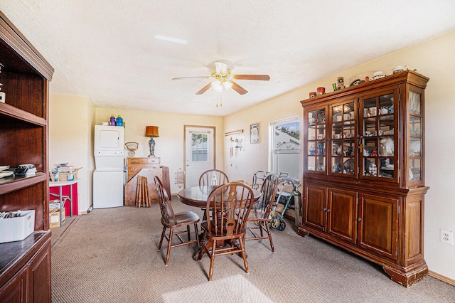 1680 W Huffman Lake Rd, Vanderbilt, MI 49795 - dining room with light colored carpet, a ceiling fan, and stacked washer and clothes dryer