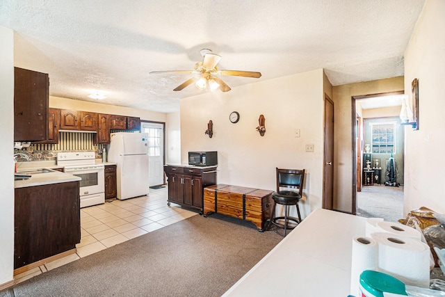 1680 W Huffman Lake Rd, Vanderbilt, MI 49795 - kitchen featuring white appliances, ceiling fan, a textured ceiling, light countertops, and light tile patterned floors