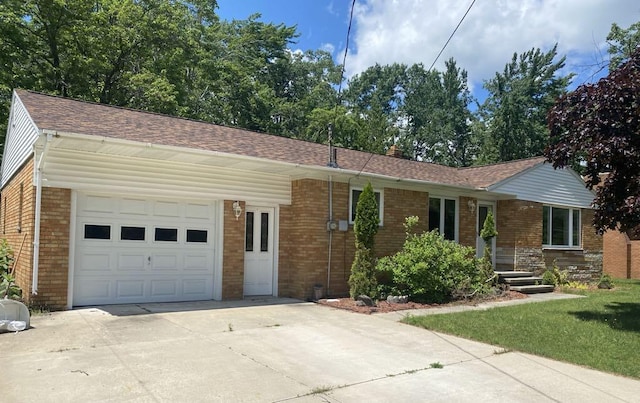 140 Oriole Dr, Alpena, MI 49707 - ranch-style home with brick siding, a garage, driveway, and a shingled roof